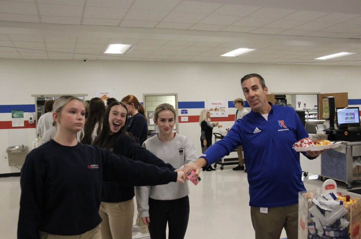 Seniors Josephine Bleizeffer, Anna Povinelli, Sophia Kelley and Mr. Michael Wantz, Assistant Principal for Student Life, are all uniting together in a team circle to fight ‘senioritis.’
photo by Annah Meehan